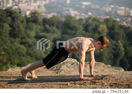 Caucasian athlete standing in plank position outdoors 79435136