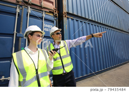 Foreman control loading Containers box from Cargo freight ship for import export. Freight containers in sea port. Cargo ship departure and arrival. Foreman control cargo loading box. Logistics and 79435484