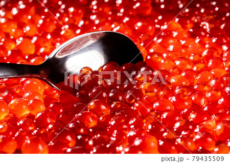 Silver spoon and red caviar close-up. Appetizing background of red caviar. 79435509