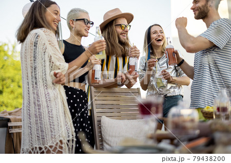 Young stylish friends having a festive dinner on the roof terrace 79438200