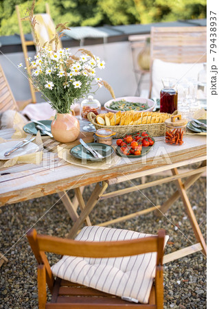 Beautifully served wooden table with food and dishes in natural boho style outdoors Beautifully served wooden table with food and dishes in natural boho style outdoors 79438937