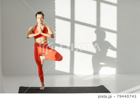 Athletic woman balancing in yoga pose indoors 79440743