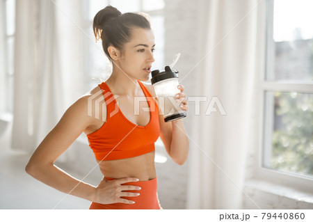 Sports woman with protein shaker at gym Sports woman with protein shaker at gym 79440860