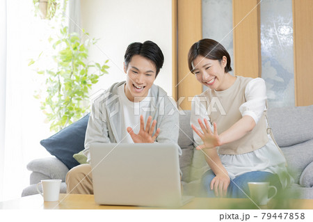 テレビ電話で実家の両親と会話をする若い夫婦 テレビ電話で実家の両親と会話をする若い夫婦 79447858