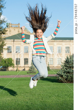 full of energy. childhood happiness. small girl with curly hair jump outdoor. full of energy. childhood happiness. small girl with curly hair jump outdoor. 79448707