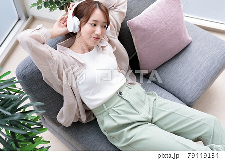 ヘッドフォンで音楽を聴きながらリラックスする若い女性 ヘッドフォンで音楽を聴きながらリラックスする若い女性 79449134