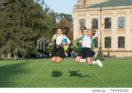 Unstoppable energy of little jumping schoolgirls school background, celebrate september concept Unstoppable energy of little jumping schoolgirls school background, celebrate september concept 79449200