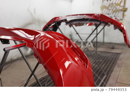 Red plastic car bumper drying after repainting in spraying booth Red plastic car bumper drying after repainting in spraying booth 79449353