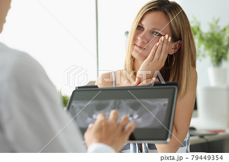 Female patient with acute toothache at doctor appointment with X-ray image 79449354