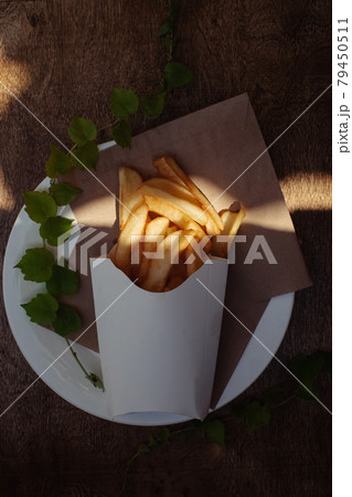 Top view of French fries. Fry dip. The concept of fast food, quick bites and restaurants for catering. Potatoes in carton and ketchup. Vertical photo. 79450511
