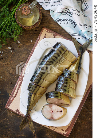Mediterranean food, seafood. Tasty Appetizing smoked mackerel with spices on dark rustic wooden table. Top view flat lay background. 79450640