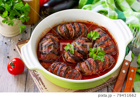 Thanksgiving day food. Homemade Baked eggplants stuffed with turkey meat in tomato sauce on wooden table. Thanksgiving day food. Homemade Baked eggplants stuffed with turkey meat in tomato sauce on wooden table. 79451662