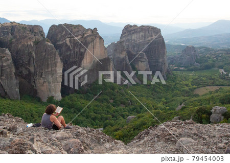 Man traveller resting, reading a book and enjoying nature on the mountains Man traveller resting, reading a book and enjoying nature on the mountains 79454003