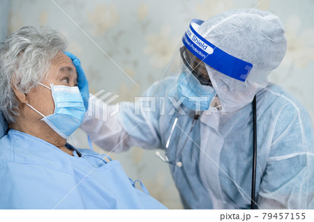 Asian doctor wearing face shield and PPE suit new normal to check patient protect safety infection Covid-19 Coronavirus outbreak at quarantine nursing hospital ward. Asian doctor wearing face shield and PPE suit new normal to check patient protect safety infection Covid-19 Coronavirus outbreak at quarantine nursing hospital ward. 79457155