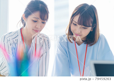 オフィスでミーティングする2人の若いビジネスウーマン 79459263