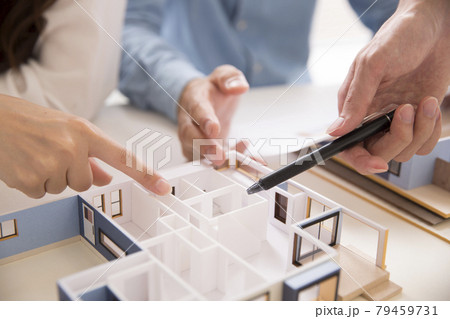 住宅模型を見ながら打ち合わせする施主と設計師 79459731
