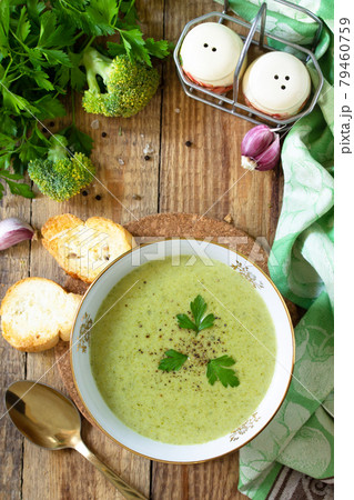Vegetarian dish. Delicious broccoli cream soup served with garlic croutons on a rustic table. Top view flat lay background. Copy space. 79460759