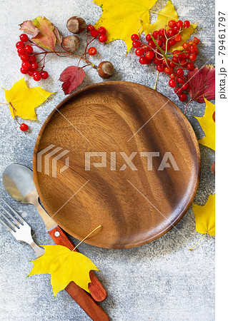 Autumn table setting. Thanksgiving or autumn harvest table setting with silverware and frame of leaves. Top view flat lay. Free space for your text. 79461797