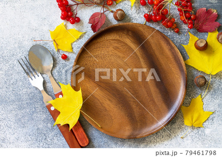 Autumn table setting. Thanksgiving or autumn harvest table setting with silverware and frame of leaves. Top view flat lay. 79461798