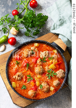 Spanish and Mexican food - Albondigas. Hot stew tomato soup with meatballs and vegetables. Top view on a flat lay. Spanish and Mexican food - Albondigas. Hot stew tomato soup with meatballs and vegetables. Top view on a flat lay. 79462559