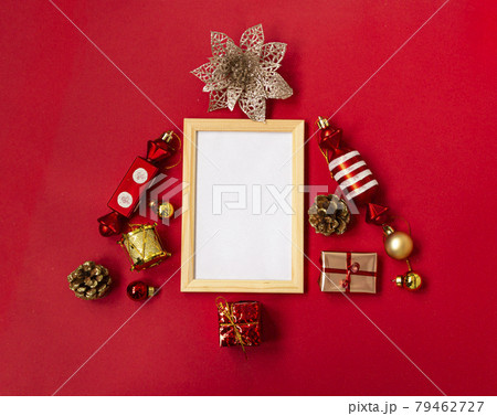 Flat composition with a Christmas tree made of different festive items, snowflakes, gifts, sweets, Christmas tree decorations on a red background. mockup. Copy space. 79462727
