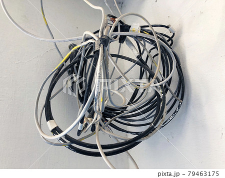 Chaotic, messy, tangled electrical wires in the house Chaotic, messy, tangled electrical wires in the house 79463175