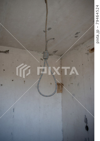 Deadly loop hanging from the ceiling in abandoned apartment. Concept of suicide, despair 79464524