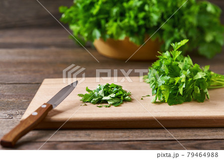 Fresh chopped green parsley leaves on a cutting board, selective focus. 79464988