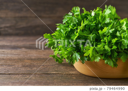 fresh parsley in a wooden bowl on the table, copy space for text. fresh parsley in a wooden bowl on the table, copy space for text. 79464990