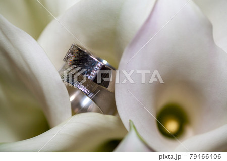 Close view on calla flowers with wedding rings in warm colors 79466406