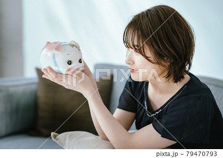 貯金箱と若い女性 79470793