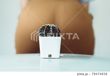 Blurred woman ass sit down on a cactus and suffering from hemorrhoids 79474658