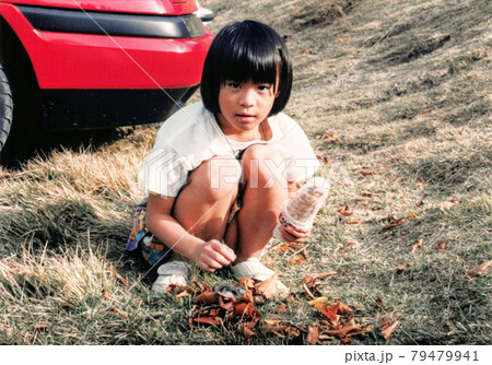 昔のフィルム写真　アイスを持ってしゃがむ女の子 79479941