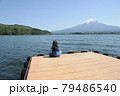 富士山の見える湖で座って釣りをする少女 79486540