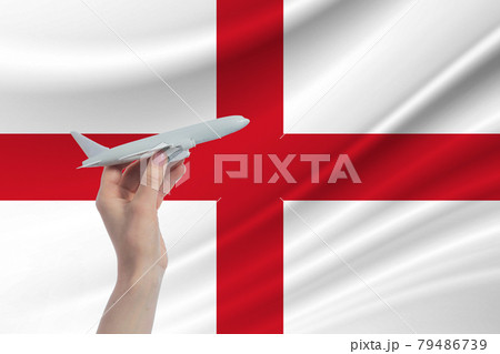Airplane in hand with national flag of England. Travel to England Airplane in hand with national flag of England. Travel to England 79486739