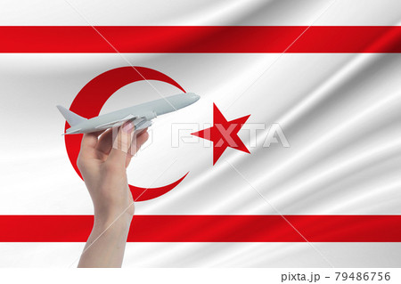 Airplane in hand with national flag of Turkish Republic of Northern Cyprus. Travel to Turkish Republic of Northern Cyprus Airplane in hand with national flag of Turkish Republic of Northern Cyprus. Travel to Turkish Republic of Northern Cyprus 79486756