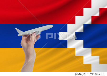Airplane in hand with national flag of Nagorno-Karabakh Republic. Travel to Nagorno-Karabakh Republic Airplane in hand with national flag of Nagorno-Karabakh Republic. Travel to Nagorno-Karabakh Republic 79486766