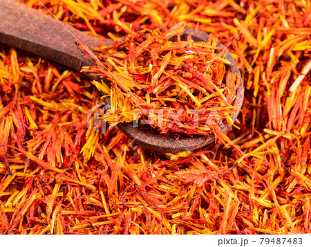 spoon on pile of dried safflower petals closeup spoon on pile of dried safflower petals closeup 79487483