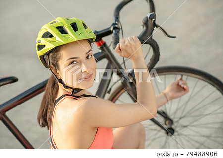 Young cyclist in bright sportswear fixing a bike wheel Young cyclist in bright sportswear fixing a bike wheel 79488906