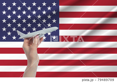 Airplane in hand with national flag of United States. Travel to United States 79489709