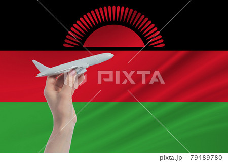 Airplane in hand with national flag of Malawi. Travel to Malawi 79489780