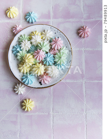 Small colorful meringues in the ceramic  plate 79489913