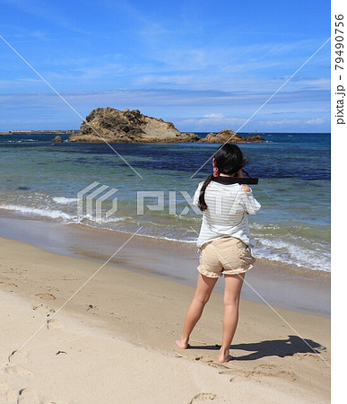 山陰海岸国定公園　京丹後市小天橋　波打ち際で写真を撮ろうとしている少女 79490756