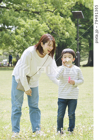 公園でしゃぼん玉遊びをする親子 79491365