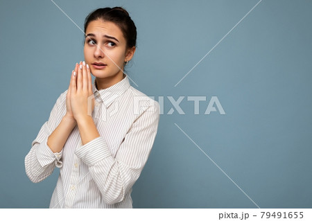 Photo of young sad worried attractive brunette woman with sincere emotions wearing white shirt Photo of young sad worried attractive brunette woman with sincere emotions wearing white shirt 79491655