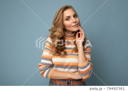 Portrait of young winsome attractive happy sexy blond woman with wavy-hair wearing striped sweater 79492561