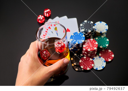 Casino chips, playing cards, glass of whiskey and dices on dark reflective background Casino chips, playing cards, glass of whiskey and dices on dark reflective background 79492637