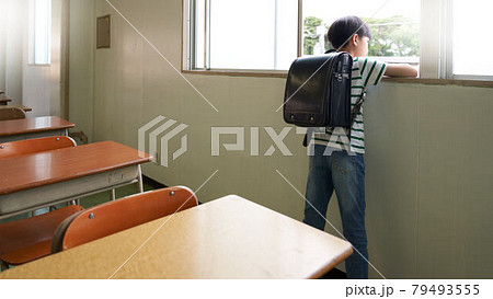 教室で窓の外を見る小学生の後ろ姿 79493555