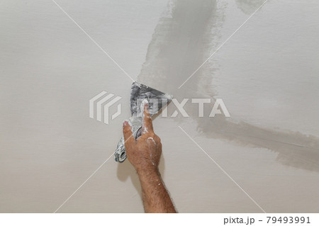 Painter fixing damaged ceiling 79493991