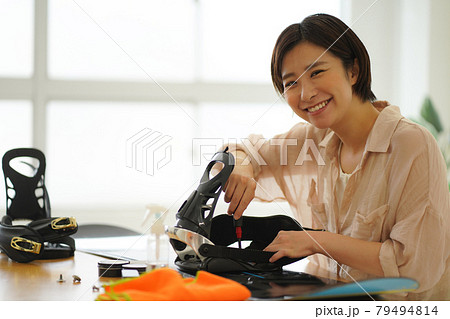 スノーボード板の手入れをする女性 79494814